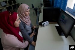 Wassan al-Sayyed,17, right, and Massa Halawa, 16, run the team's virtual reality game "Be a Fire Fighter" in the West Bank city of Nablus, Aug. 2, 2018. Four Palestinian high school friends are heading to California this week to pitch their mobile app about fire prevention to Silicon Valley's tech leaders.