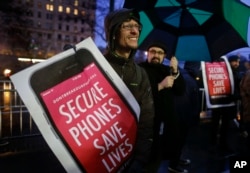 FILE - Protesters demonstrate against a government demand that Apple unlock an iPhone at a rally outside the Apple store on Fifth Avenue in New York, Feb. 23, 2016.