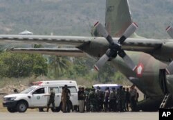 A coffin containing the body of one of the victims of a military helicopter crash in Poso, Central Sulawesi, is loaded into a cargo plane to be transported to Jakarta at the airport in the provincial capital of Palu, Indonesia, March 21, 2016.