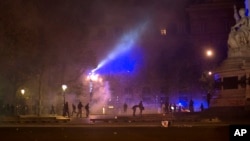 Demonstrators run away from tear gas during clashes with police in Paris, April 23, 2017.