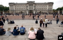 FILE - Tourists gather around Buckingham Palace in London, May 19, 2016.