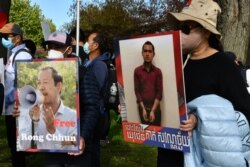 បាតុករ​កាន់​ផ្ទាំង​បដា​ដែល​មាន​រូប​លោក រ៉ុង ឈុន មេដឹកនាំសហជីព​ និង​យុវជន​ដែល​បាន​ជាប់​ពន្ធនាគារ​ដោយ​សារ​ការ​បញ្ចេញ​មតិ​រិះគន់​តាម​បណ្តាញ​សង្គម ក្នុង​អំឡុង​បាតុកម្ម​មួយ​នៅ​រដ្ឋធានី​វ៉ាស៊ីនតោន កាល​ពី​ថ្ងៃ​ទី​២២ ខែ​តុលា ឆ្នាំ​២០២១។ (ម៉ែន គឹមសេង/វីអូអេ)