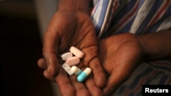 FILE - Nine-year-old Tumelo shows off antiretroviral (ARV) pills before taking his medication at Nkosi's Haven, south of Johannesburg, South Africa, Nov. 28, 2014. Seven million people in the country are currently living with the HIV virus.