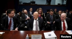 Then-FBI Director James Comey, from left, then-U.S. Director of National Intelligence James Clapper and then-CIA Director John Brennan take their seats to testify on Capitol Hill in Washington, Feb. 25, 2016.