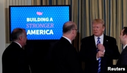 U.S. President Donald Trump speaks to attendees as he departs his infrastructure initiative meeting at the White House in Washington, U.S., Feb. 12, 2018.