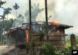FILE - Houses are on fire in Gawdu Zara village, northern Rakhine state, Myanmar, Sept. 7, 2017.