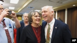 FILE -Greg Gianforte, right, receives congratulations from a supporter, March 6, 2017, in Helena, Mont., after winning the Republican nomination for Montana's special election for U.S. House.