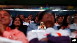 Prime Minister Narendra Modi of India is reflected in a glass barrier as he gives a speech during a reception by the Indian community in honor of his visit to the United States at Madison Square Garden, Sunday, Sept. 28, 2014.