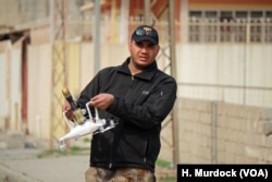 An Iraqi soldiers transports an IS armed drone after it fell from the sky in Mosul, Iraq, Feb. 12, 2017.
