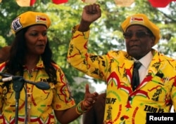 FILE - President Robert Mugabe and his wife, Grace, attend a rally of his ruling ZANU-PF party in Harare, Zimbabwe, Nov. 8, 2017.