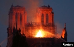 Fire fighters douse flames of the burning Notre Dame Cathedral in Paris, April 15, 2019.