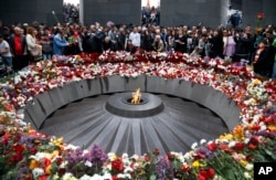 FILE - People lay flowers at a memorial to Armenians killed by the Ottoman Turks, as they mark the centenary of the mass killings, in Yerevan, Armenia, April 24, 2015.