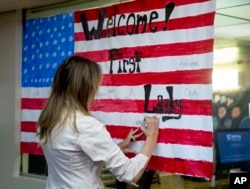 First lady Melania Trump signs an American Flag while visiting the Upbring New Hope Children Center run by the Lutheran Social Services of the South in McAllen, Texas, June 21, 2018.