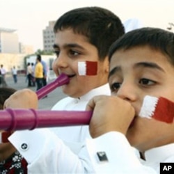 Qatari boys with their faces painted in the colors of their national flag, blow vuvuzelas, celebrating the emirate's selection as the host for the 2022 World Cup, Doha, Dec. 2, 2010.