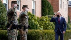 El presidente Joe Biden devuelve un saludo mientras camina por Marine Barracks Washington después de visitar la tienda Honey Made, el martes 25 de enero de 2022, en Washington DC.