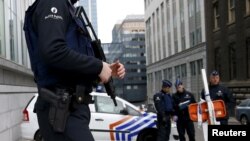 FILE - Belgian police officers secure an access to the federal police headquarters in Brussels, March 19, 2016, after Salah Abdeslam, the most-wanted fugitive from November's Paris attacks, was arrested after a shootout with police in Brussels on Friday.