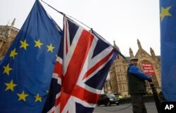 An anti-Brexit campaigner waves flags in Westminster in London, Dec. 4, 2018.