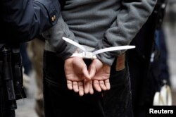 FILE - An Occupy Wall Street subject stands in plastic handcuffs after being arrested by New York police, Nov. 17, 2011.