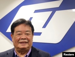 Cao Dewang, chairman of Fuyao Glass, a Chinese-based leading supplier of automotive glass worldwide, poses in front of the corporate logo at the primary Fuyao Glass production plant in the United States, in Moraine, Ohio, Sept. 30, 2016.