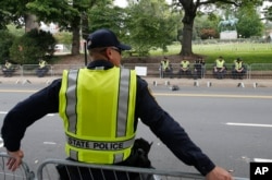 State Police patrol the road in front of Market Street park with the statue of Confederate General Robert E. Lee as they lock down the downtown area in anticipation of the anniversary of last year's Unite the Right rally in Charlottesville, Va., Aug. 11, 2018.