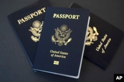 In this May 9, 2017 photo, U.S. passports lie on a table in Dallas, Texas. The U.S. State Department is in the middle of a record year for processing passport applications, with 20.5 million renewals and applications for new passports expected.