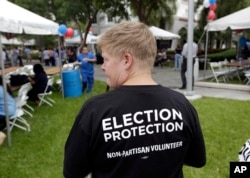 Lisa Hubbard, a volunteer with the non-partisan Election Protection Coalition, attends an early voting celebration outside of Jackson Memorial Hospital, on the first day of early voting in Miami-Dade County for the general election, Oct. 24, 2016, in Miam