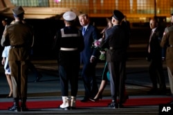 President Donald Trump and first lady Melania Trump pass an honor guard as they walk toward their vehicle after arriving at Chopin Airport, in Warsaw, Poland, July 5, 2017.