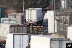 FILE - South Korean cargo trucks head to the North Korean city of Kaesong as South Korean Army soldiers stand guard at the customs, immigration and quarantine office near the border village of Panmunjom in Paju, South Korea, Feb. 11, 2016.