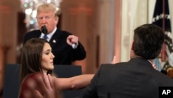 FILE - President Donald Trump points to CNN's Jim Acosta, a White House aide takes the microphone from him during as a news conference in the East Room of the White House, Nov. 7, 2018, in Washington.