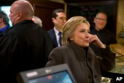 Democratic presidential candidate Hillary Clinton speaks with co-owner of the Puritan Backroom restaurant, as she picks up her order, in Manchester, N.H., Feb. 7, 2016.