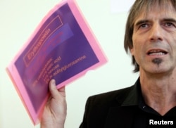 Director of the Swiss anti-doping laboratory Martial Saugy holds papers of a presentation during a news conference in Lausanne, January 11, 2013, as he reacts to declarations of Travis Tygart, Head of USADA that Saugy met with cyclist Lance Armstrong and gave him the key to EPO testing.