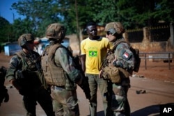 FILE - French Sangaris peacekeepers are seen speaking to a resident outside Fatima Church in Bangui, Central African Republic.