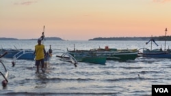 FILE - A Filippino fisherman removes tow ropes of his boat before heading out into the South China Sea, in Masinloc, Philippines, Nov. 8, 2015. Fishermen in the Philippines hope Duterte's visit to China will help them regain access to disputed waters.