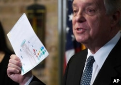 U.S. Sen. Dick Durbin, D-Ill., holds a card written by a Chicago child at a news conference, June 22, 2018, in Chicago. This and other cards were later shown to children detained as a result of President Donald Trump's policy of separating families at the border.