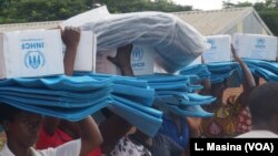 Flood survivors in Phalombe district, Malawi, carry relief items distributed by the UNHCR.