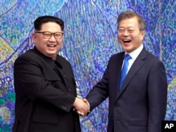 North Korean leader Kim Jong Un, left, poses with South Korean President Moon Jae-in for a photo inside the Peace House at the border village of Panmunjom in Demilitarized Zone, April 27, 2018.