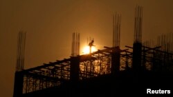 FILE - Men work at a construction site of a hotel in Hanoi, Vietnam, Jan. 7, 2016.