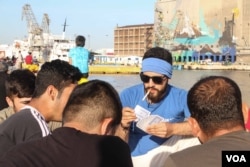 Along the dock, groups of men can be found fishing to supplement their meals and pass the hours, Athens, Greece, April 15, 2016. (Photo: J. Owens/VOA)