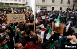 Police members stand guard as people protest against President Abdelaziz Bouteflika, in Algiers, Algeria, March 8, 2019.