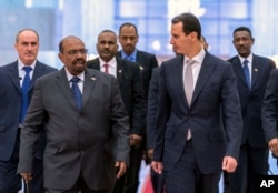 FILE - In this photo released by the Syrian official news agency SANA, Dec. 16, 2018, Syrian President Bashar Assad, right, meets with Sudan's President Omar Bashir in Damascus, Syria.