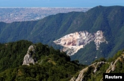 FILE - A view of a marble quarry and the coast of Versilia from the Monte Altissimo in the Apuan Alps, Tuscany, Italy, July 18, 2017.