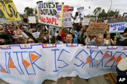 FILE - Protesters rally against the Dakota Access Pipeline behind the 128th Rose Parade in Pasadena, Calif., Jan. 2, 2017.