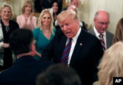 FILE - President Donald Trump greets people as he arrives to speak during a dinner for evangelical leaders in the State Dining Room of the White House, Aug. 27, 2018, in Washington.