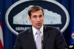 Assistant Attorney General for National Security John Demers speaks during a news conference to announce a criminal law enforcement action involving China, at the Department of Justice in Washington, Nov. 1, 2018.