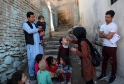 FILE - A health worker administers a polio vaccine to a child in Kabul, Afghanistan, March 29, 2021.