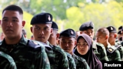 Soldiers and other people line up for their early vote for the upcoming Thai election at a polling station in Narathiwat province, Thailand, March 17, 2018.