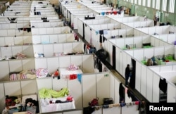 FILE - A shelter houses thousands of refugees inside a hangar of the former Tempelhof airport in Berlin, Germany, Dec. 9, 2015.