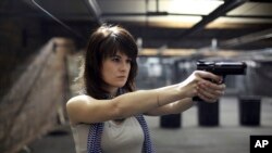 FILE - Maria Butina, a gun-rights activist poses for a photo at a shooting range in Moscow, Russia, April 22, 2012.