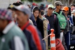 Los migrantes centroamericanos esperan en fila para una comida en un refugio en Tijuana, México, el miércoles 14 de noviembre de 2018.