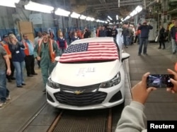 FILE - Employees watch as the last Chevrolet Cruze rolls off the assembly line at the General Motors Co. assembly plant in Lordstown, Ohio, March 6, 2019, in this photo obtained from social media.
